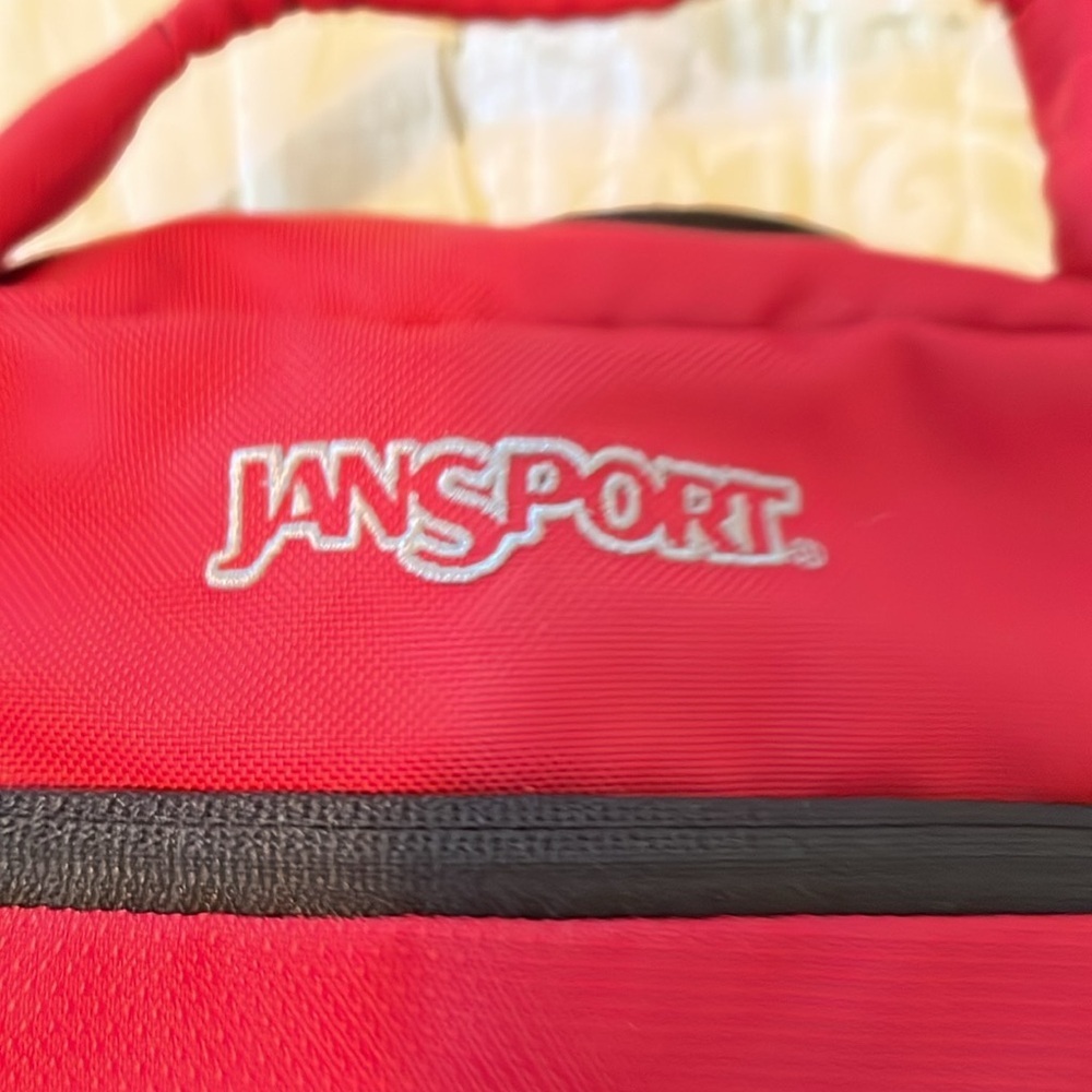 Red Jansport laptop messenger bag. Interior Velcro & outer zippered compartment